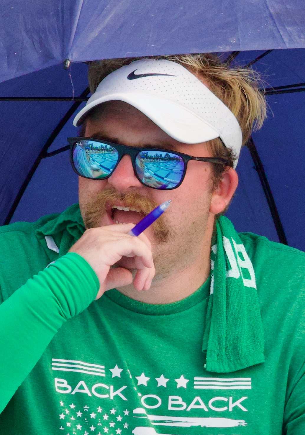 Tannor Enyart on the pool deck under a purple umbrella